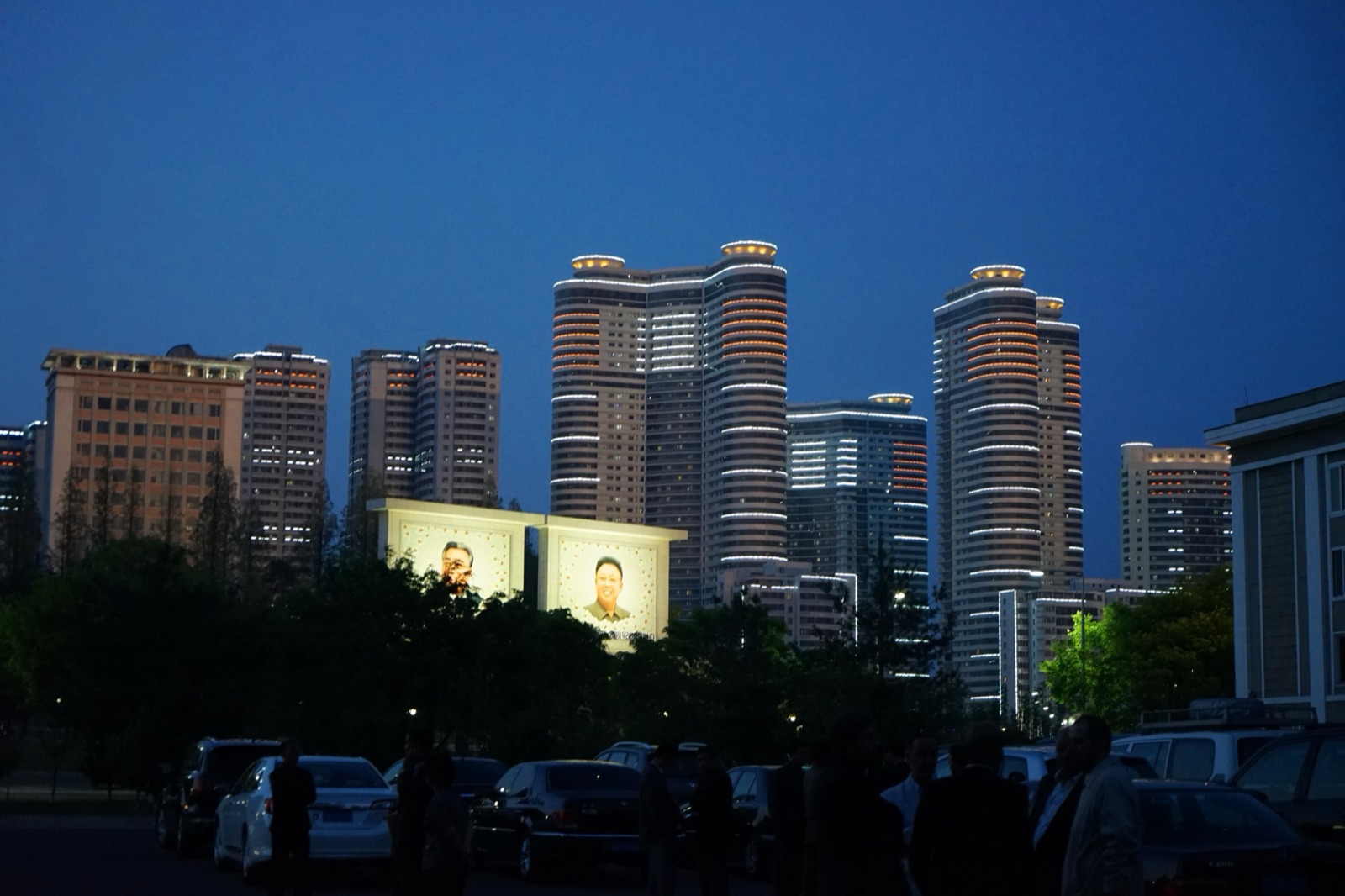Vista nocturna de Pionyang, la capital de Corea del Norte, con los retratos de Kim Il-sung y Kim Jong-il iluminados.