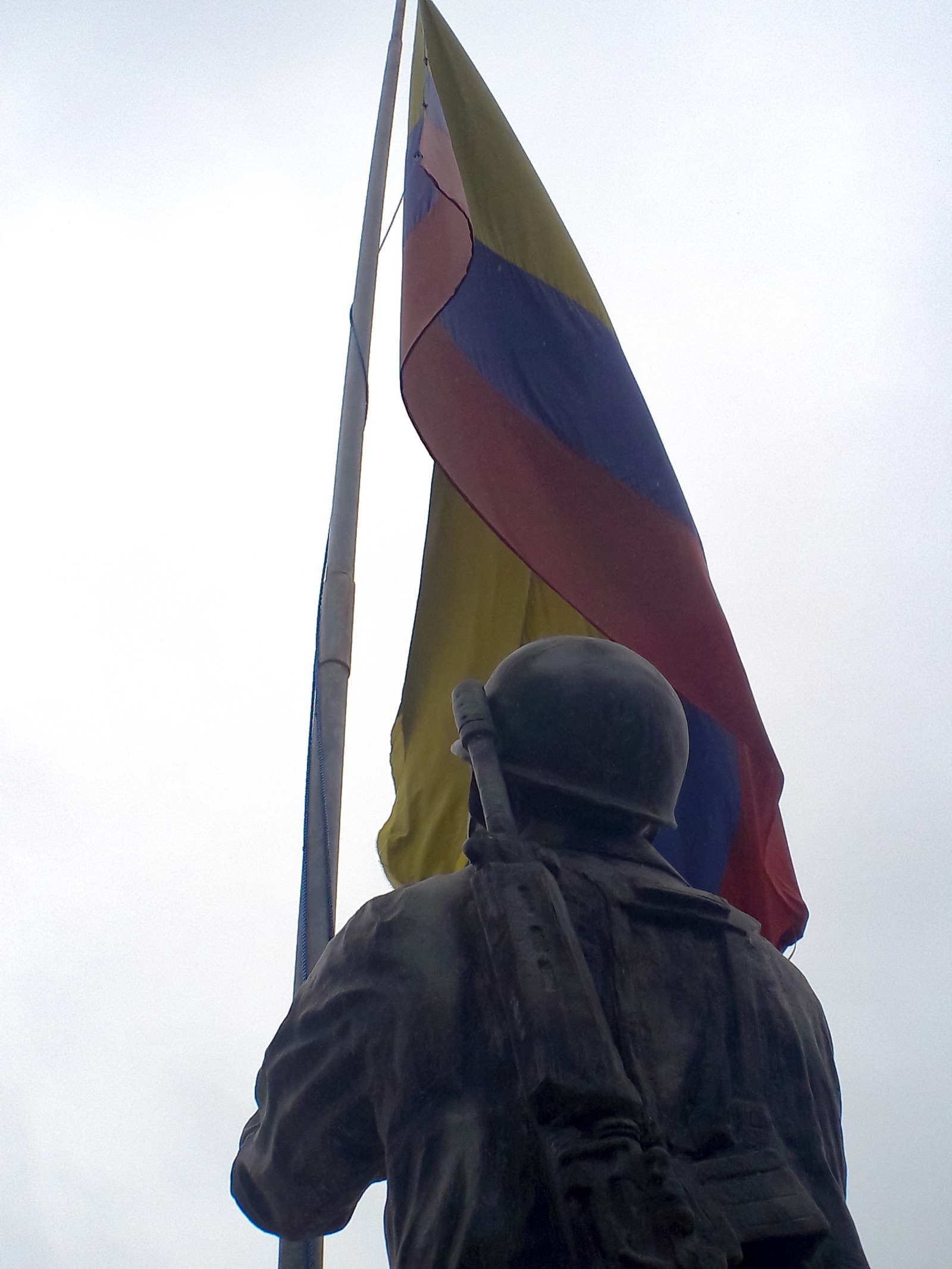 Monumento a los Héroes del Cenepa en la parroquia El Cambio, en Ecuador: la estatua de un soldado frente a la bandera ecuatoriana.
