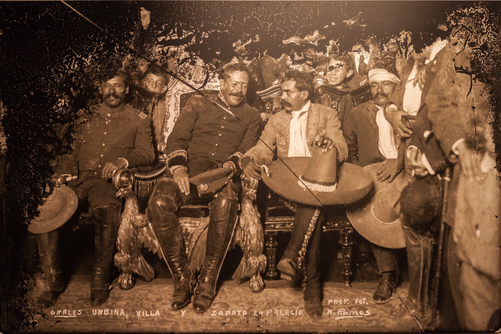Tomás Urbina, Francisco Villa (en la silla presidencial) y Emiliano Zapata en el Palacio Nacional, el 6 de diciembre de 1914. Copia de la foto expuesta en el Museo de la Ciudad de México.
