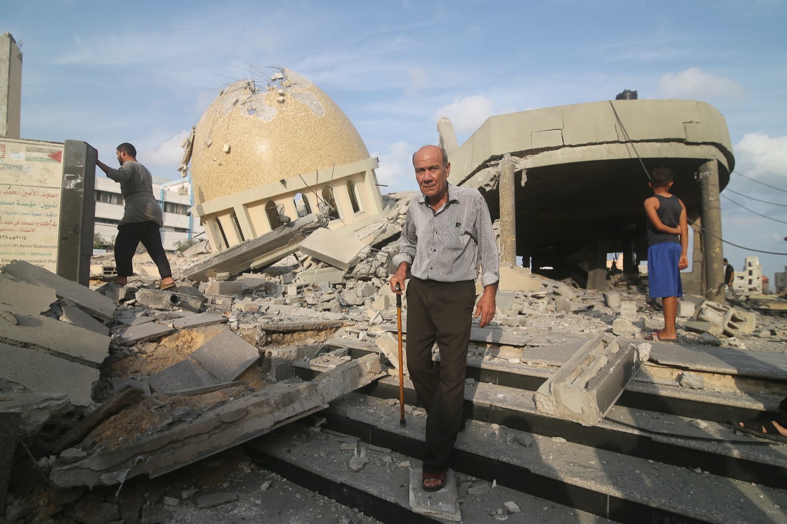Palestinos inspeccionan las ruinas de un edificio destruido por ataques aéreos israelíes en Jan Yunis, en octubre de 2023 (foto de archivo).