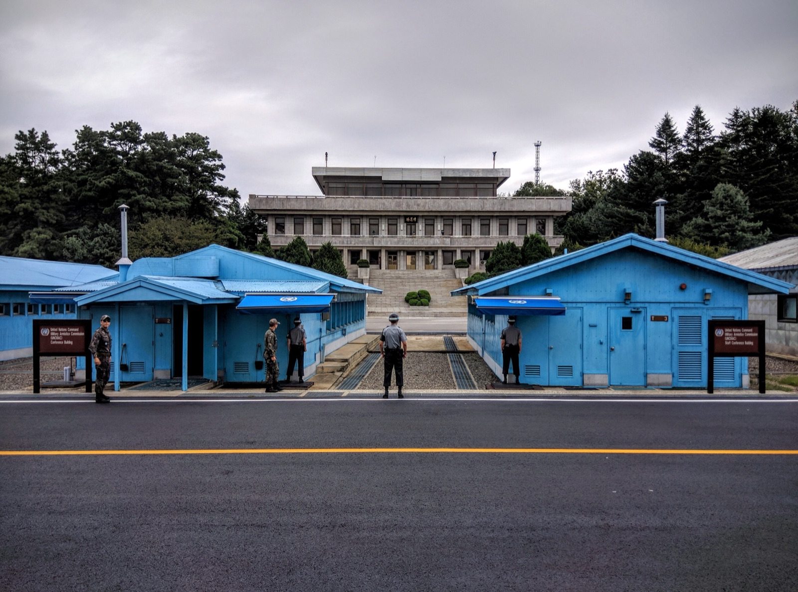 Las casetas azules del Área de Seguridad Conjunta de Panmunjom, construidas sobre la línea que divide a las dos Coreas; al fondo, un edificio del lado norcoreano (2016).